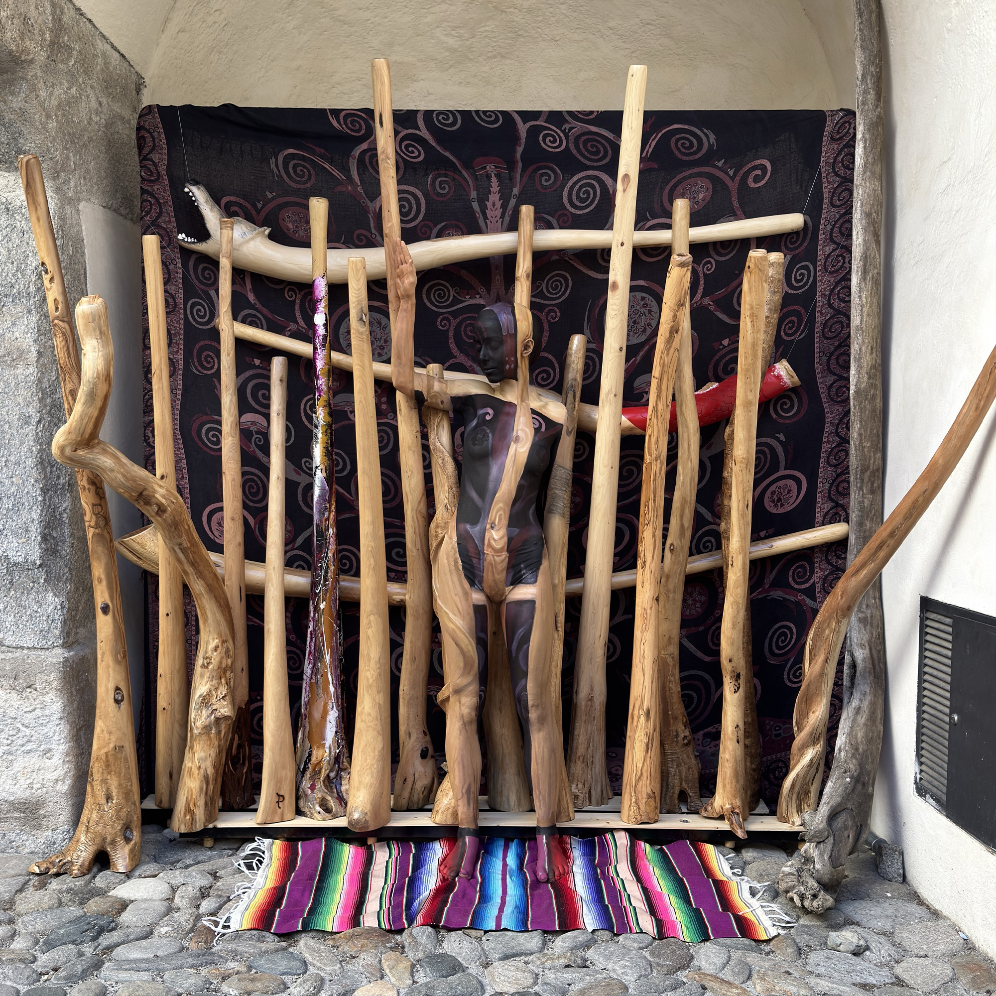 L'œuvre gagnante : la modèle Emma fondue dans un décor de didgeridoos et de bois sculpté